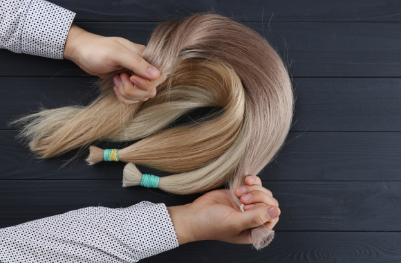 the male hand holds sections of hair for extension 2023 11 27 05 24 49 utc 2